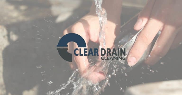 Hand washing dish over sink with water running